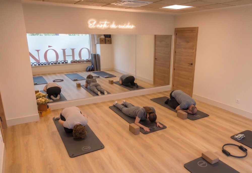 Sala de fisiopilates en NOHO Fisioclinic Zaragoza con alumnos realizando ejercicios de estiramiento y control motor en grupos reducidos.